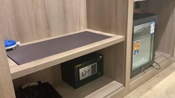 A room with a wooden desk, a black storage unit, and a glass cabinet with a sticker.