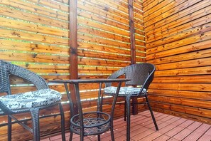 A covered outdoor area with wooden slats, wicker chairs, and a small table. - Accompanying Hotel·Yipin (Shanghai Lujiazui Financial and Trade Zone) (Shanghai)