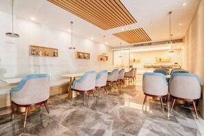A modern dining area with marble flooring, contemporary chairs, and pendant lighting. - Accompanying Hotel·Yipin (Shanghai Lujiazui Financial and Trade Zone) (Shanghai)