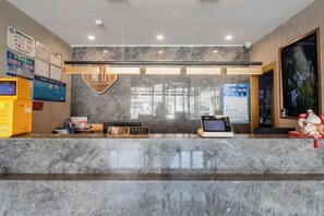 A hotel reception area with a marble counter, a heart-shaped light fixture, and a digital kiosk. - Accompanying Hotel·Yipin (Shanghai Lujiazui Financial and Trade Zone) (Shanghai)