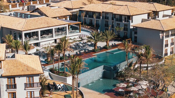 Un complexe hôtelier doté d’une piscine centrale, de nombreux espaces de détente et de divers aménagements pour se détendre en plein air.