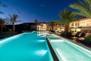Une piscine offrant une vue sur un bâtiment d’hôtel et des palmiers.
