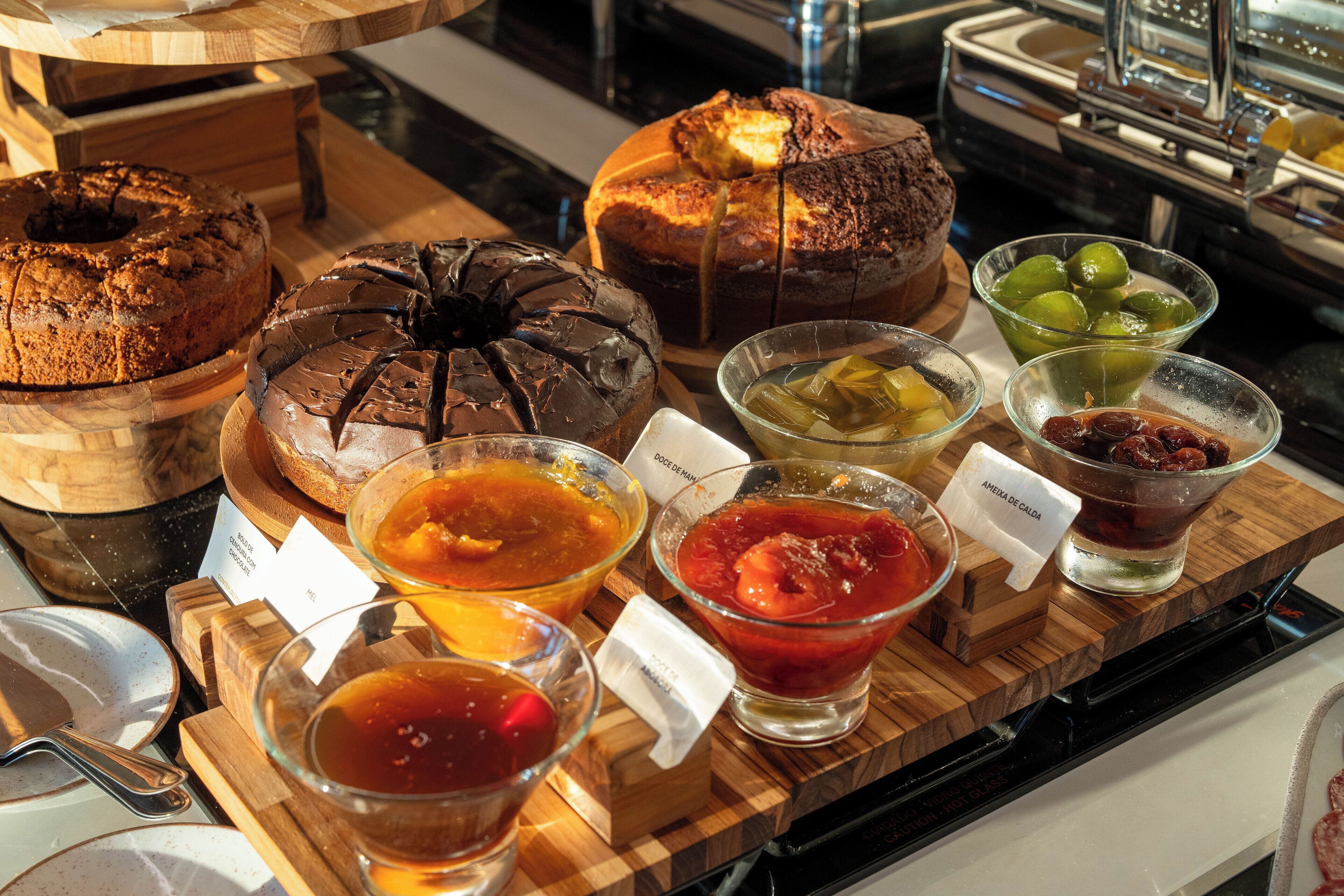 A variety of baked goods and beverages on a wooden serving board.