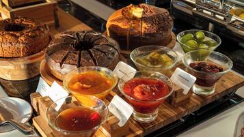 A variety of baked goods and beverages on a wooden serving board.