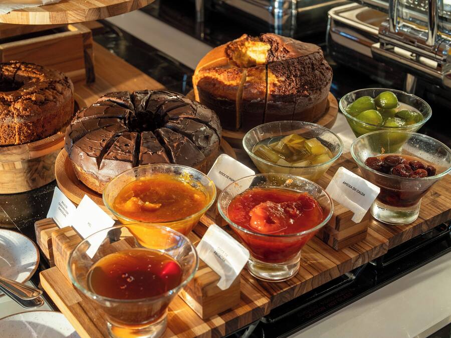 A variety of baked goods and beverages on a wooden serving board.