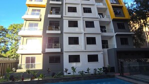 Un edificio alto con una piscina al frente.