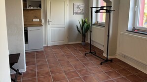 Une cuisine avec une porte blanche, une plante en pot et un radiateur.