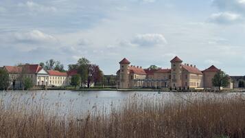A historic building with a large water body in front.