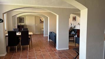 Ein Innenraum mit Essbereich, Wohnzimmer und Küche.
