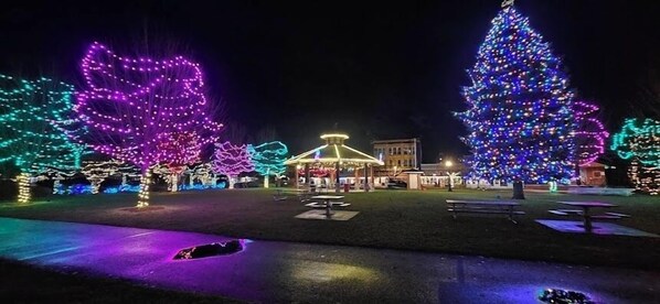 A park with illuminated trees and a gazebo.