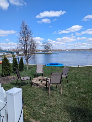 A lakeside patio with outdoor seating and a fire pit. - Beautiful Lakefront home, pets welcome, fully fenced, dock, kayaks, fishing!! (Leesburg)