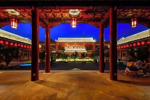 Un bâtiment traditionnel doté d’une cour intérieure, de piliers rouges richement décorés et de lanternes.