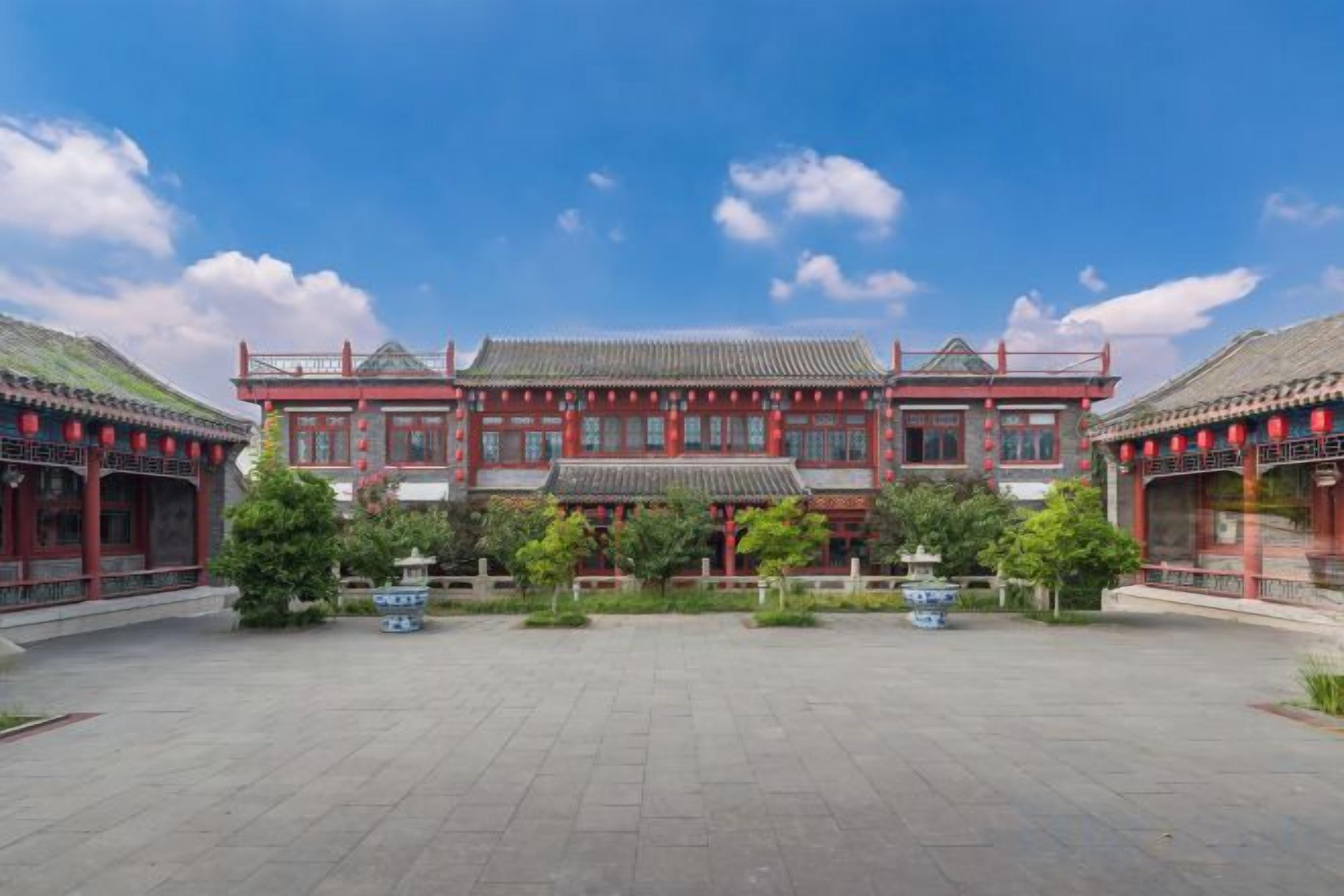 A traditional building with a symmetrical facade, a central courtyard, and a tiled roof.