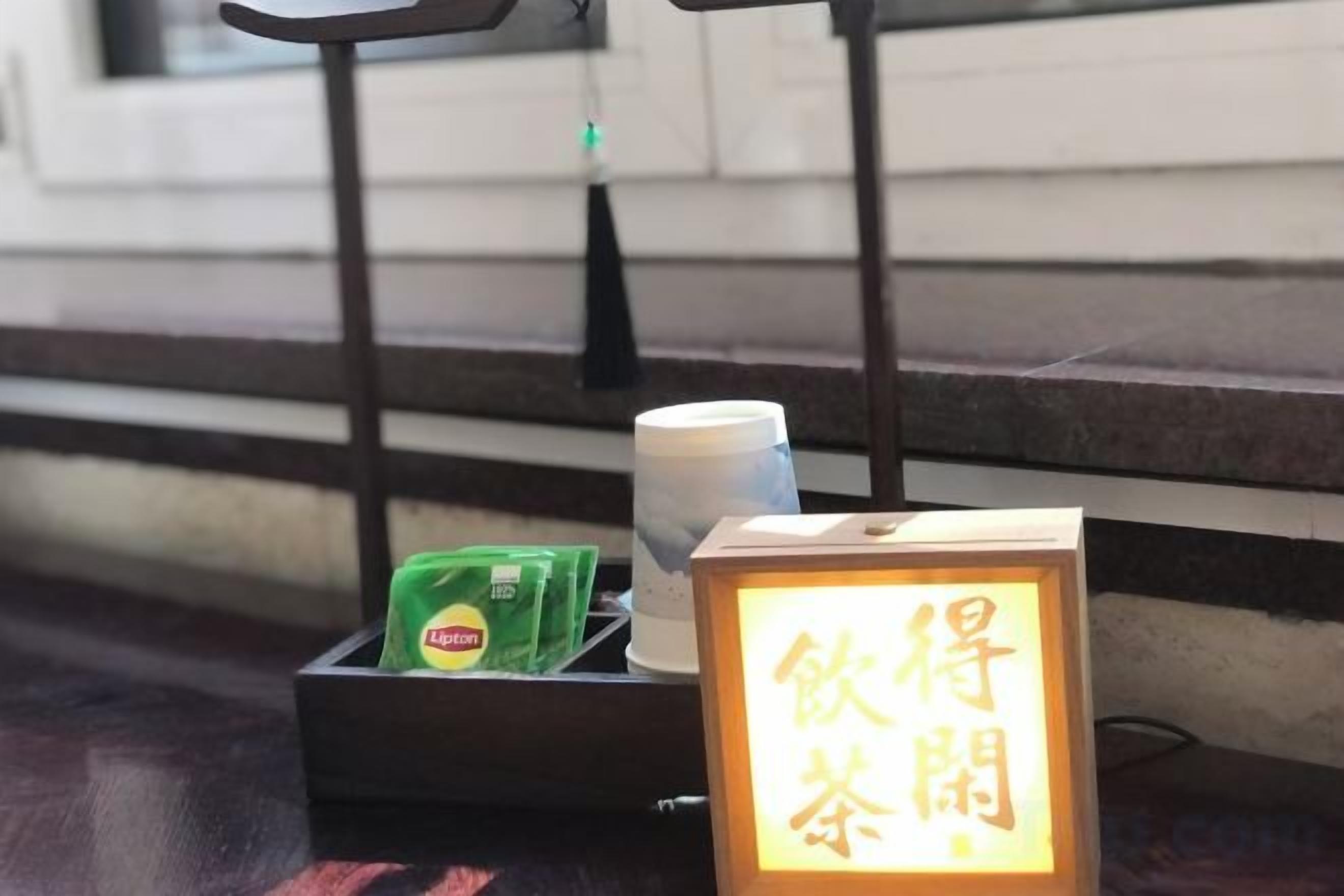 A table with a cup, a packet of tea, and a sign with Chinese characters.