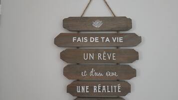 Ein hölzernes Schild mit der Aufschrift 'Fais de ta vie un rêve et du rêve une réalité' und 'Antoine de Saint-Exupéry'.