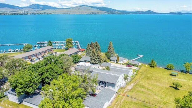 A lakeside hotel with a marina, multiple buildings, and a large body of water. - Mission Mountain Shores at Flathead Lake (Polson)