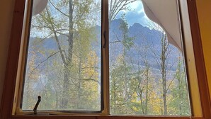 Une fenêtre avec un cadre en bois et un store blanc.