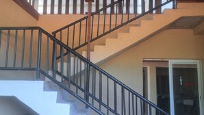 A staircase with black railings and white steps, leading to a landing. - Comfort Palace  (Kasane)