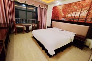 A hotel room with a bed, a small table, a chair, a window with curtains, and a painting on the wall. - Shanghai Blue Wave Wan Boutique Hotel (Songjiang Station) (Shanghai)
