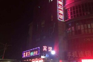 Un bâtiment doté d’enseignes lumineuses, dont une pour un hôtel et une autre pour un opérateur de réseau mobile.