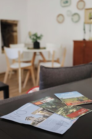 Une table à manger avec des brochures et une nappe noire.