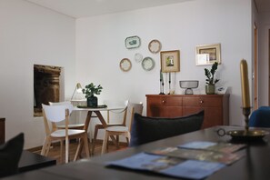 Un comedor con mesa, sillas, un armario y adornos en la pared.