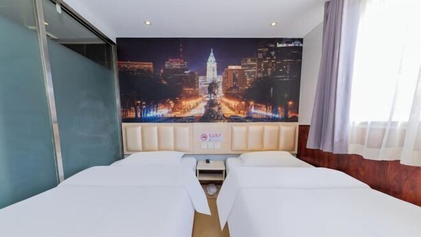 Une chambre d’hôtel avec un grand lit, une fresque représentant un paysage urbain sur le mur et une fenêtre avec des rideaux.