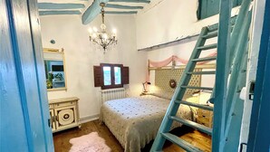 A bedroom with a bunk bed, a chandelier, a dresser, a mirror, and a window with shutters. - RIOJANIA HEREDAD (Santa Eulalia Bajera)
