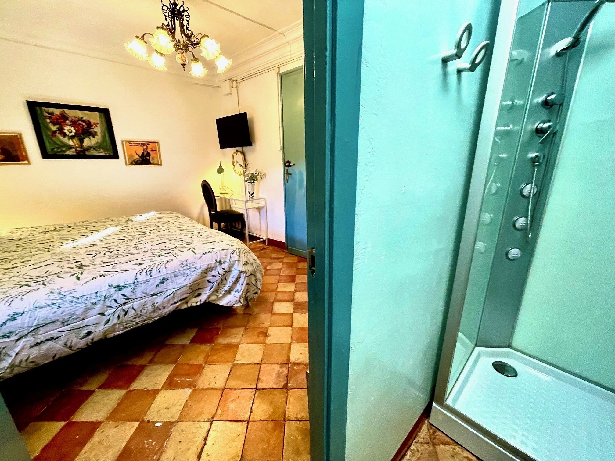 Une chambre à coucher comprenant un lit, un bureau, une chaise, un téléviseur et une salle de bain avec une baignoire.