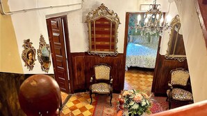 A room with ornate wooden furniture, a chandelier, and a patterned carpet. - RIOJANIA HEREDAD (Santa Eulalia Bajera)