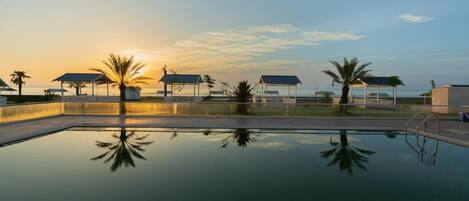 Outdoor pool, pool umbrellas, lifeguards on site