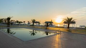 Outdoor pool, pool umbrellas, lifeguards on site