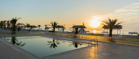 Outdoor pool, pool umbrellas, lifeguards on site