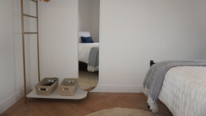 A bedroom with a bed, a mirror, a wooden ladder, and two baskets on a shelf. - Charming 2 bedroom apartment, recently refurbished, great location pet friendly! (Anlaby)