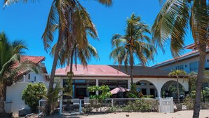 A beachfront property with a covered patio, palm trees, and a sandy beach. - Beachfront AC Villa, 3BR, 3.5BA,  great surfing! Free Parking (Guanacaste Province)