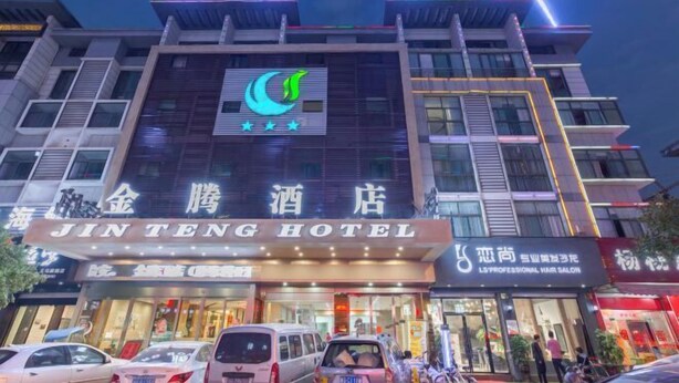 A hotel with a prominent sign reading "JINTENG HOTEL" and a logo featuring a crescent moon. - Jinteng Hotel (Yiwu)