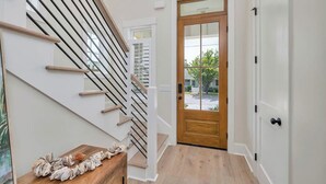 A staircase with wooden handrails and a wooden table with decorative items.