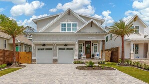 A two-story house with a front garage, a covered porch, and a landscaped driveway.