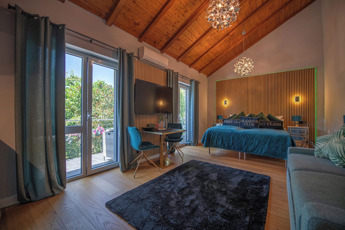 A bedroom with a bed, a desk, and a TV.