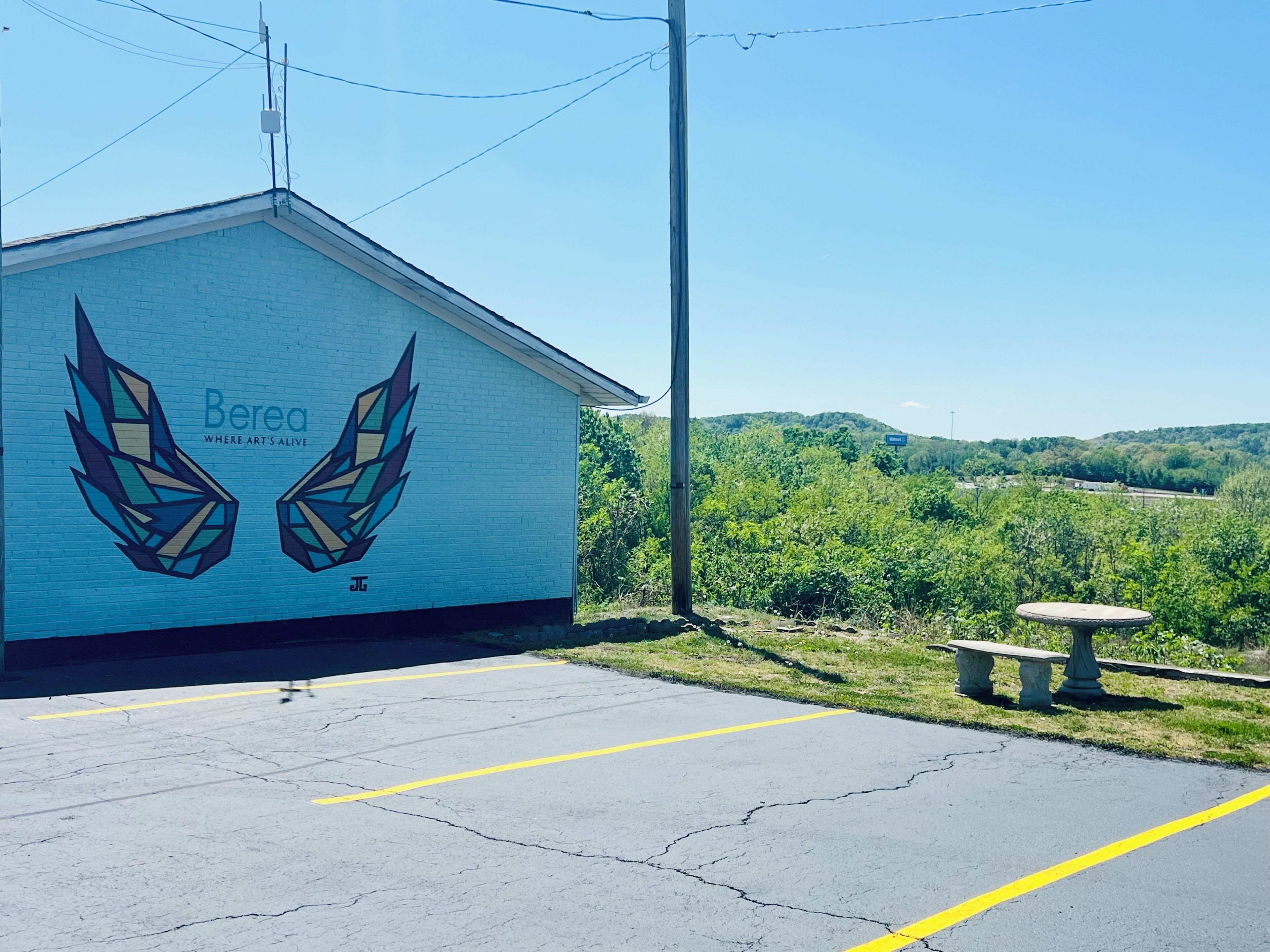 A building with a mural of geometric wings and the text 'Berea Where Art's Alive' on its side.