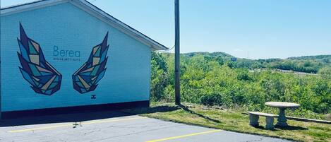 A building with a mural of geometric wings and the text 'Berea Where Art's Alive' on its side.