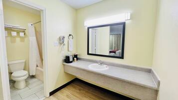 Une salle de bain avec des toilettes, un lavabo et un miroir.