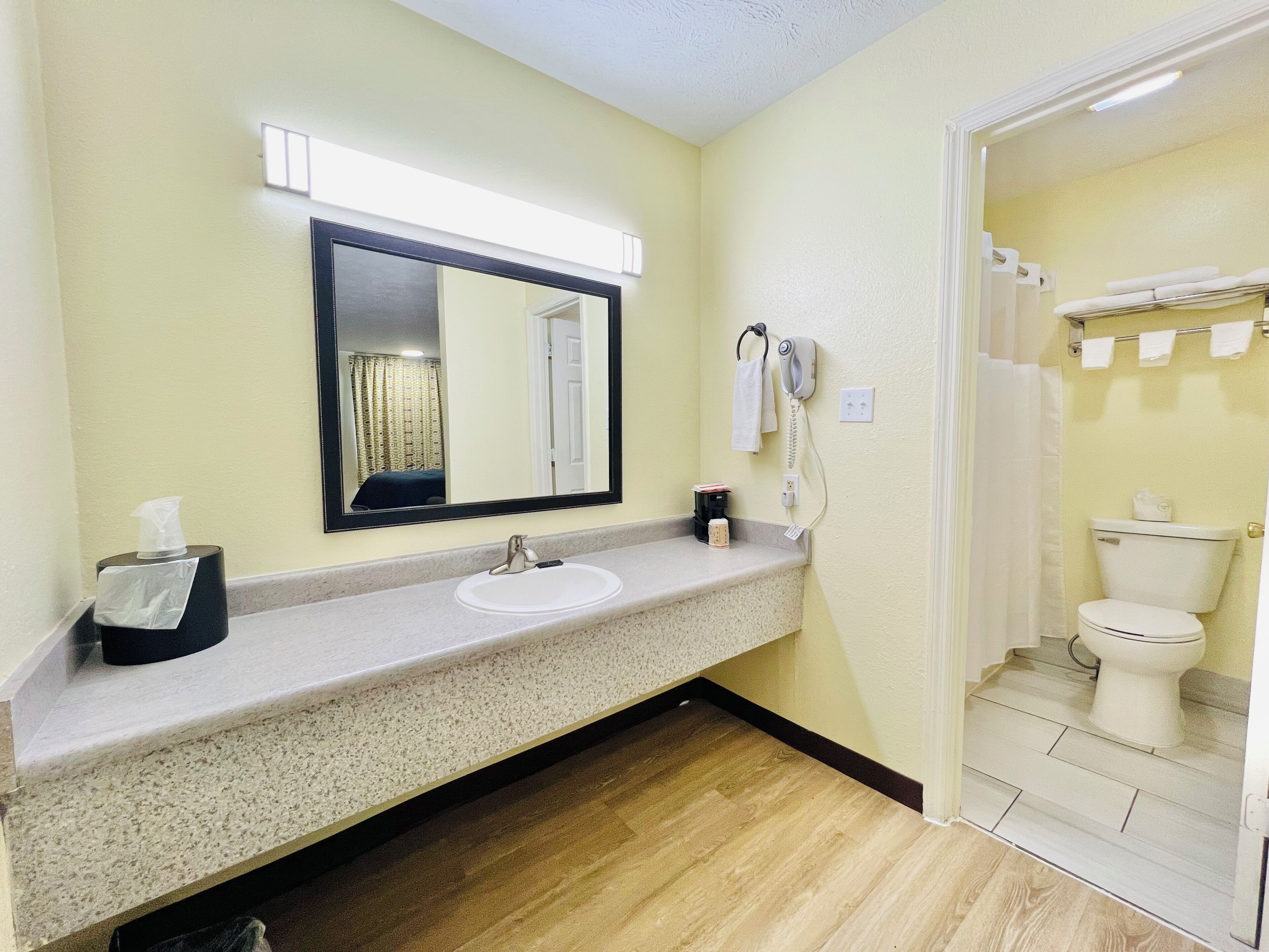 A bathroom with a sink, mirror, towel rack, and toilet.