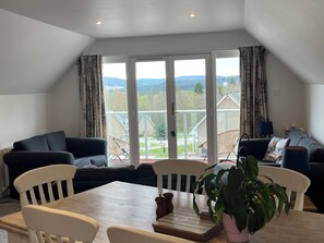 Relax in a spacious living area with a high ceiling and stunning mountain views.