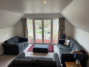 Relax in this spacious living room with a balcony offering views of the surrounding neighborhood.
