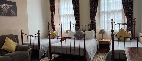 Une chambre de style traditionnel, dotée d’un lit à baldaquin, d’un canapé et d’une table.