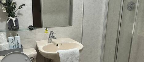 Ein Badezimmer mit Toilette, Waschbecken und Dusche.