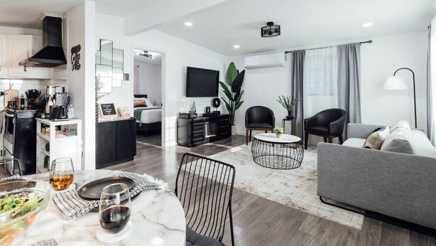 A modern apartment with a kitchen, dining area, and living room.