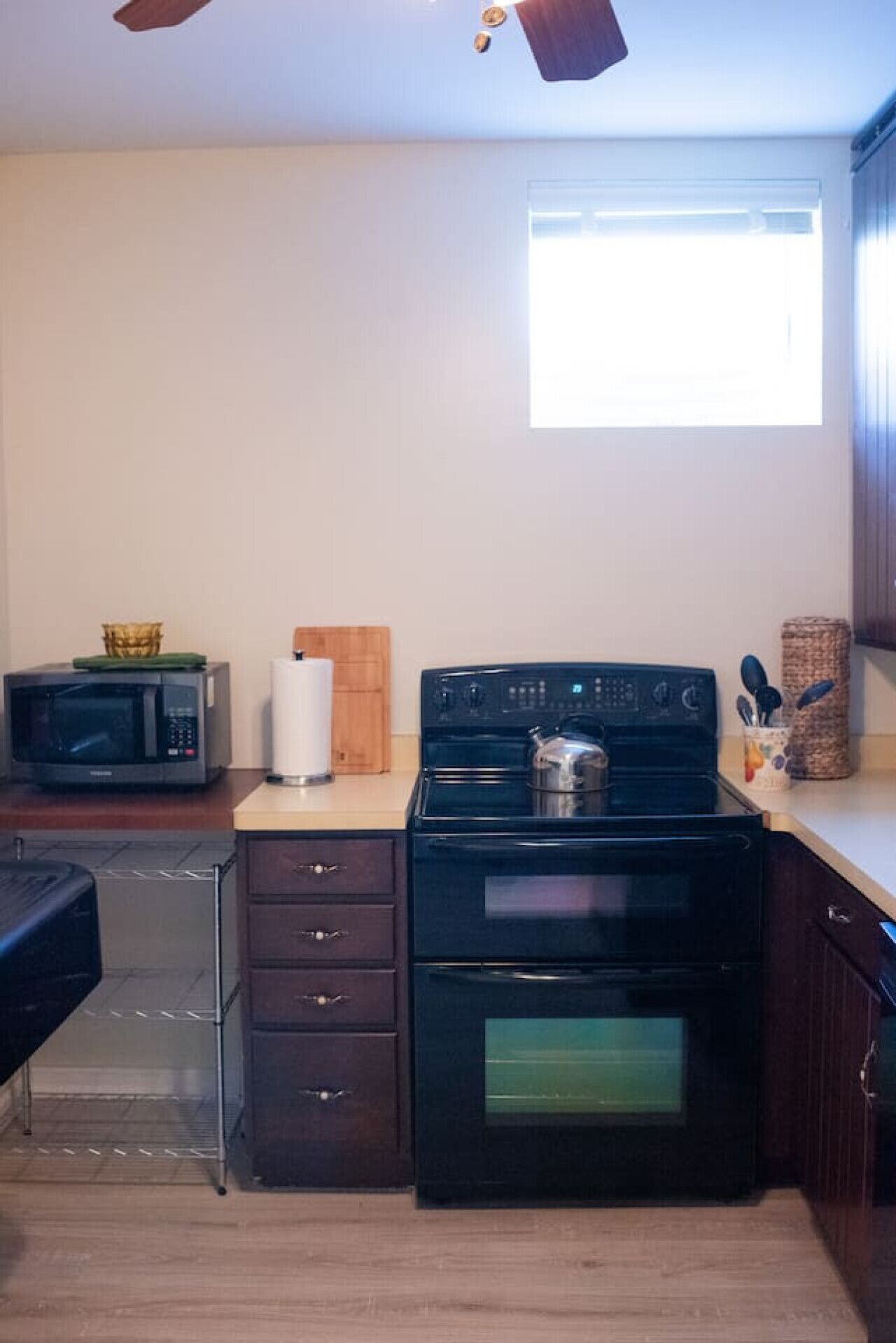 Une cuisine compacte équipée d’une cuisinière, d’un four à micro-ondes et d’un petit plan de travail.