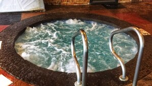 A hot tub with metal railings in a room with wooden flooring and a tiled border. - Vista Ridge Retreat at Deer Ridge Mountain Resort (Gatlinburg)